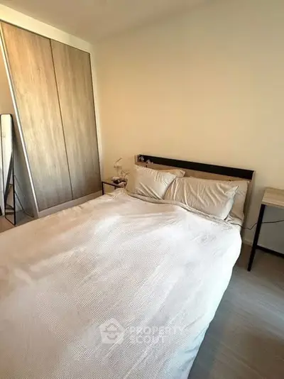 Cozy bedroom with modern design and ample natural light, featuring a comfortable bed and sleek wardrobe.