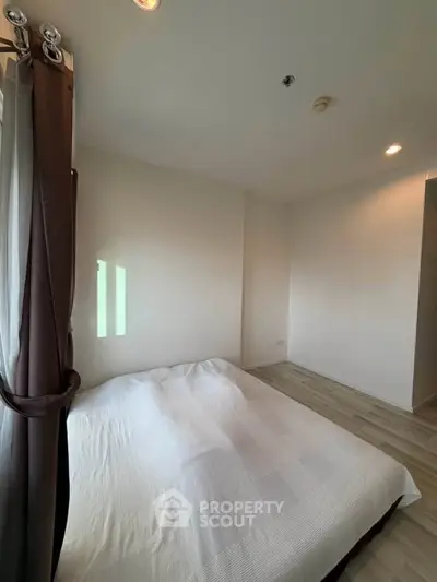Spacious bedroom with natural light and modern decor in a stylish apartment.