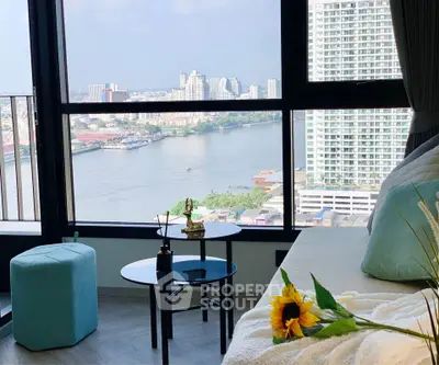 Stunning river view from modern high-rise apartment with cozy interior decor.