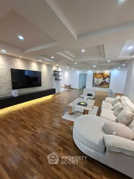 Spacious modern living room with elegant lighting and wooden flooring