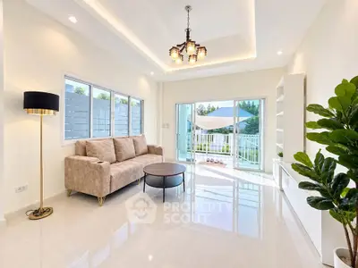 Spacious living room with modern decor and large windows opening to a balcony with a view.