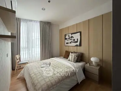 Modern bedroom with stylish decor and natural light, featuring a cozy bed and elegant furnishings.
