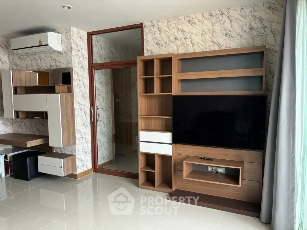 Modern living room with stylish wooden shelving and TV unit, marble accent wall, and air conditioning.