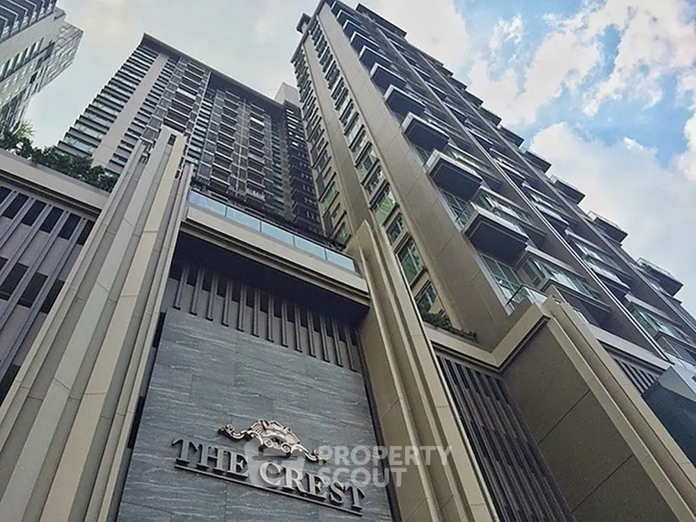 Stunning view of The Crest luxury condominium building against a blue sky.