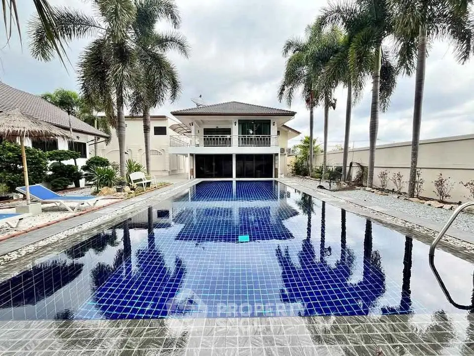Luxurious villa with stunning pool and palm trees, perfect for tropical living.