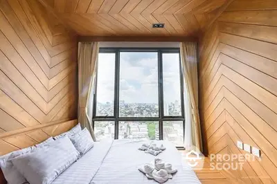 Charming bedroom with herringbone wood paneling and panoramic city view through floor-to-ceiling windows, offering a serene urban retreat.