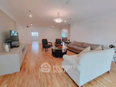 Spacious living room with elegant furniture and wooden flooring in a modern apartment.