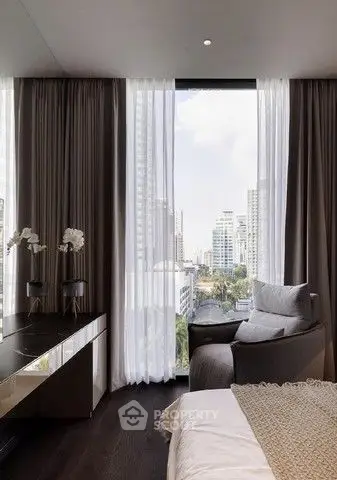 Luxurious bedroom with floor-to-ceiling window offering stunning city view.