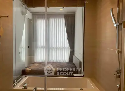Modern bathroom with glass partition and view of cozy bedroom