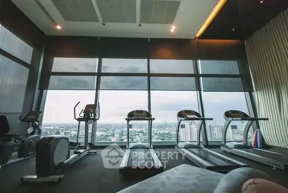 Luxurious high-rise gym with panoramic city views and modern fitness equipment.