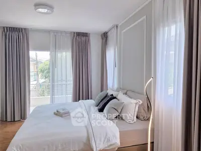 Elegant bedroom with modern decor and large windows offering natural light