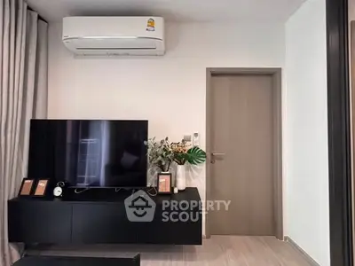 Modern living room with sleek TV setup and air conditioning unit, perfect for comfortable living.