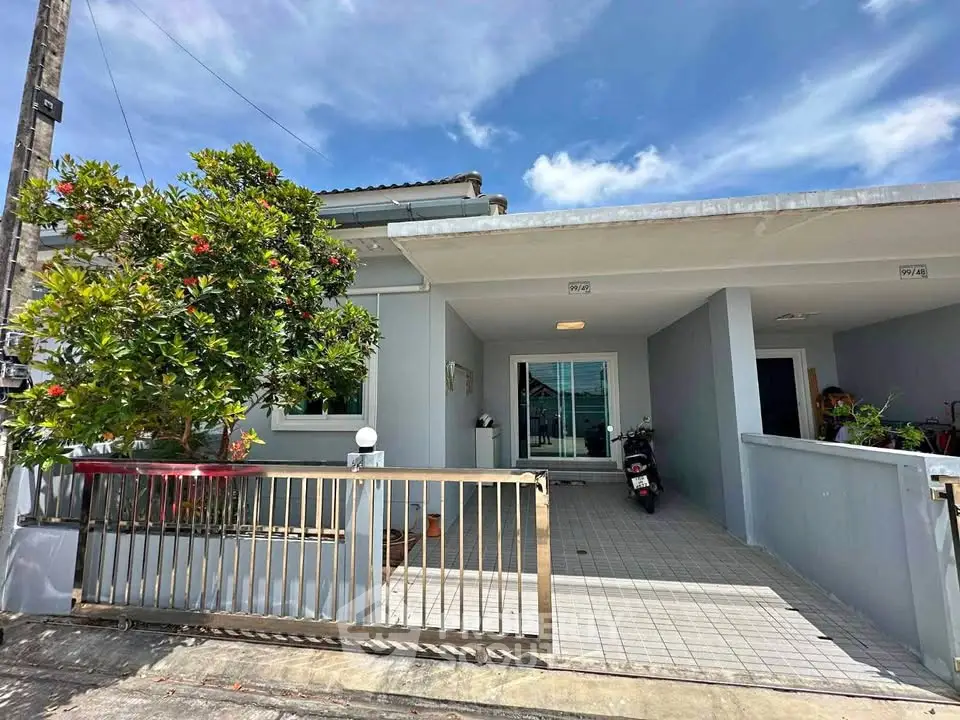 Charming single-story home with gated entrance and lush greenery, perfect for modern living.