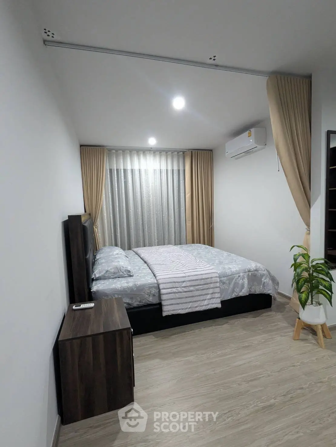 Modern bedroom with elegant decor and natural light, featuring a cozy bed and stylish furnishings.