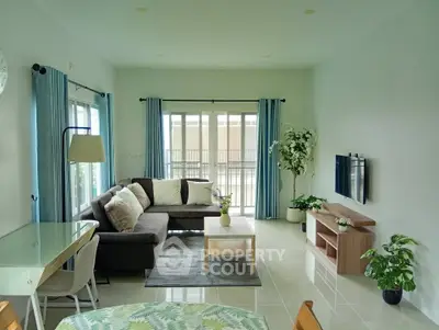 Spacious living room with modern decor, large windows, and stylish furniture in a bright apartment.