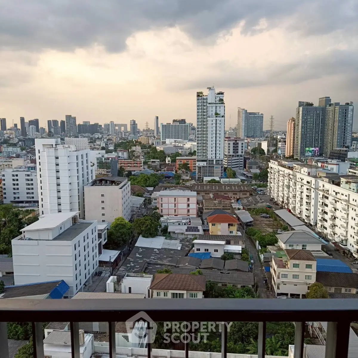 Stunning cityscape view from a high-rise balcony showcasing urban skyline and residential buildings.