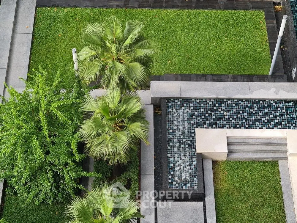 Aerial view of modern garden with lush greenery and stylish tiled water feature.