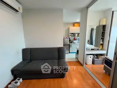 Modern apartment interior with cozy living room and open kitchen layout, featuring wooden flooring and sleek furniture.