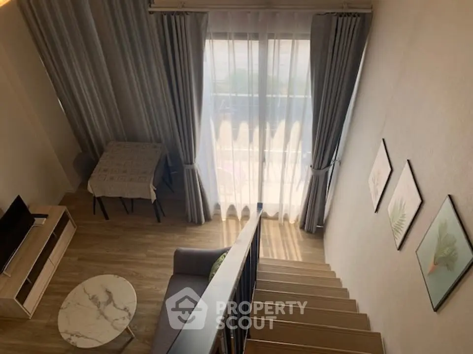 Modern loft-style living room with high ceilings and large windows, featuring stylish decor and wooden flooring.