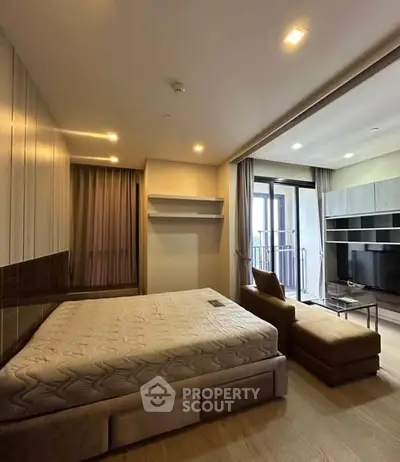 Modern bedroom with balcony access and stylish furniture in a contemporary apartment.