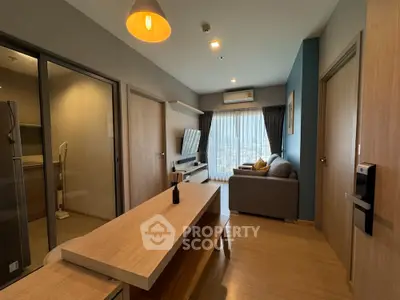 Modern studio apartment with sleek furniture, full-length windows, and a cozy sleeping area, perfect for urban living.