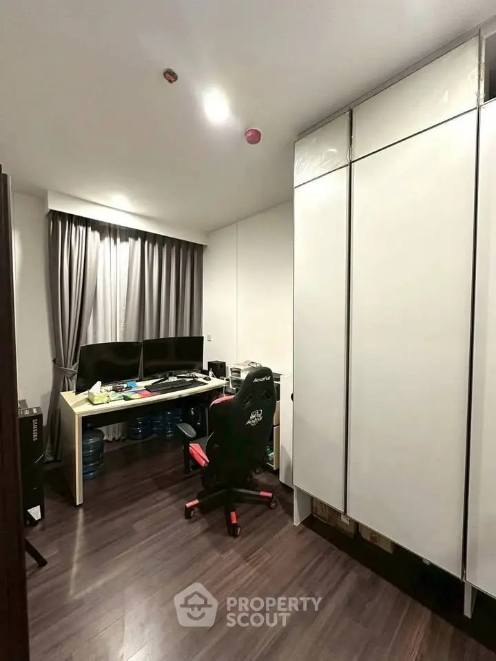Modern study room with sleek desk, dual monitors, and ergonomic chair in stylish apartment.