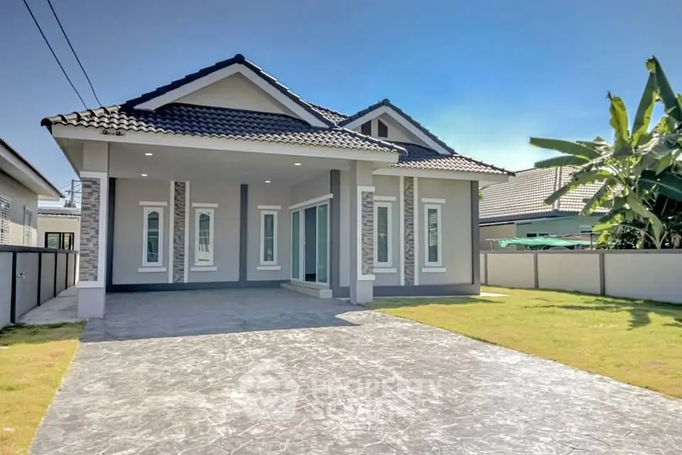 Modern single-story house with spacious driveway and manicured lawn