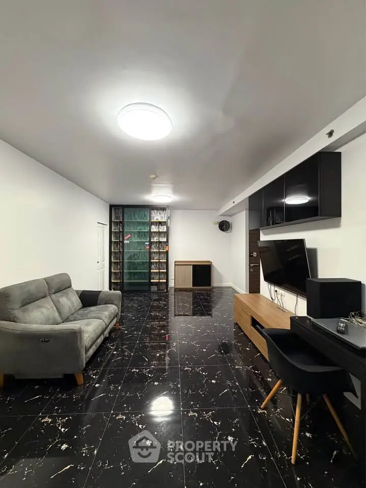 Spacious modern living room with sleek black marble flooring and stylish furniture.