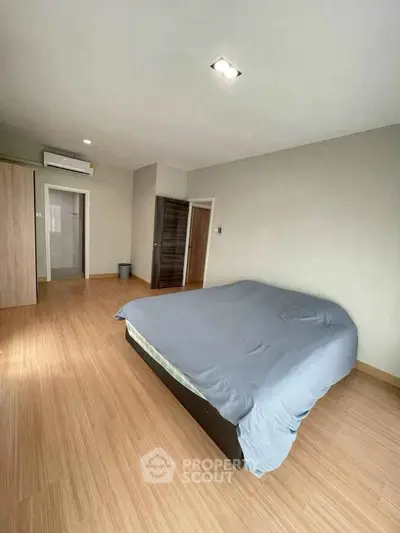 Spacious bedroom with modern design and wooden flooring in a cozy apartment.