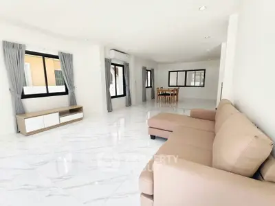 Spacious living room with modern furniture and large windows in a bright, open layout.