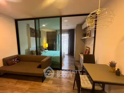 Modern studio apartment with glass partition, cozy living area, and stylish decor.