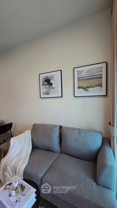 Cozy living room with modern gray sofa and stylish wall art, perfect for relaxation and comfort.