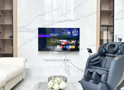 Luxurious living room with modern TV setup and massage chair, perfect for relaxation and entertainment.