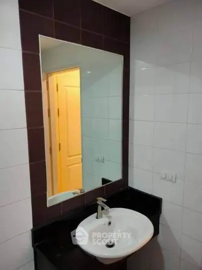 Modern bathroom with sleek sink and large mirror, ideal for contemporary living.