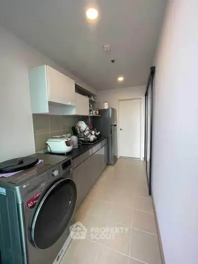Modern kitchen with sleek appliances and ample storage space in a stylish apartment.