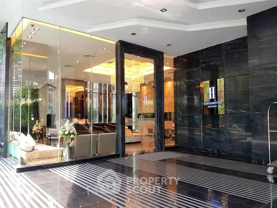Luxurious modern building entrance with elegant glass doors and chic interior design.