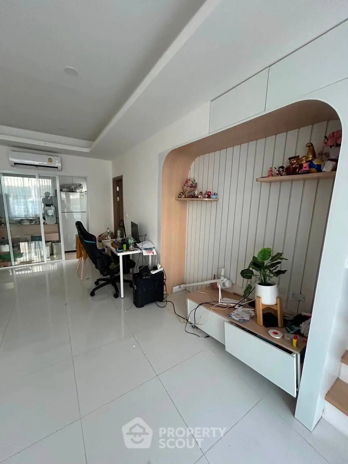 Modern living room with sleek white tiles and built-in shelving, perfect for stylish urban living.