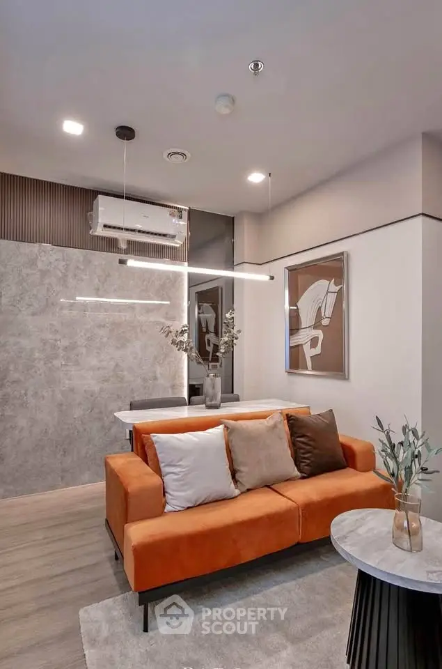 Modern living room with orange sofa and stylish decor in a contemporary apartment.