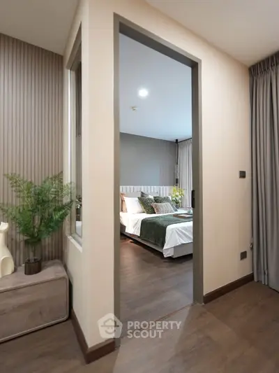 Modern bedroom with elegant decor and wooden flooring, featuring a cozy bed and stylish furnishings.