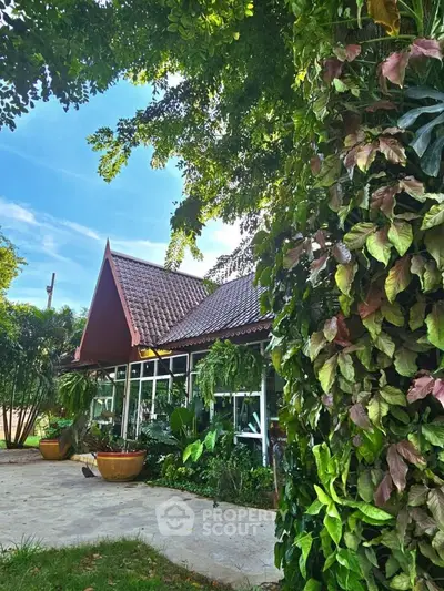 Charming tropical house with lush garden and unique roof design
