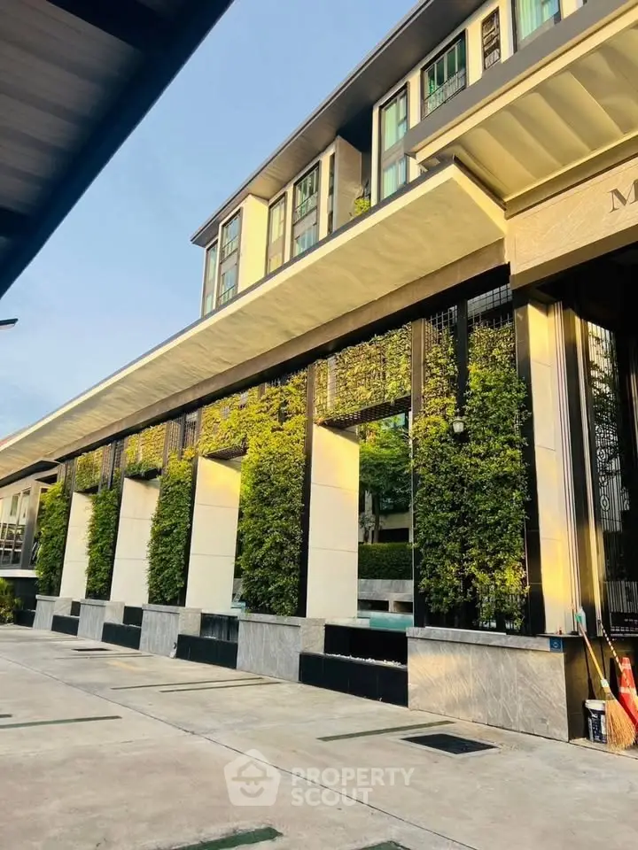 Modern building exterior with lush vertical garden and sleek architectural design.