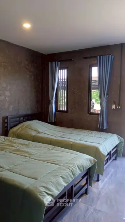Cozy bedroom with twin beds and natural light, perfect for relaxation.