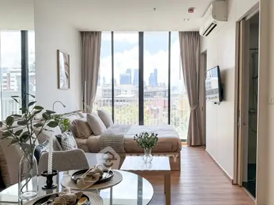 Modern studio apartment with city view, featuring cozy living area and elegant decor.