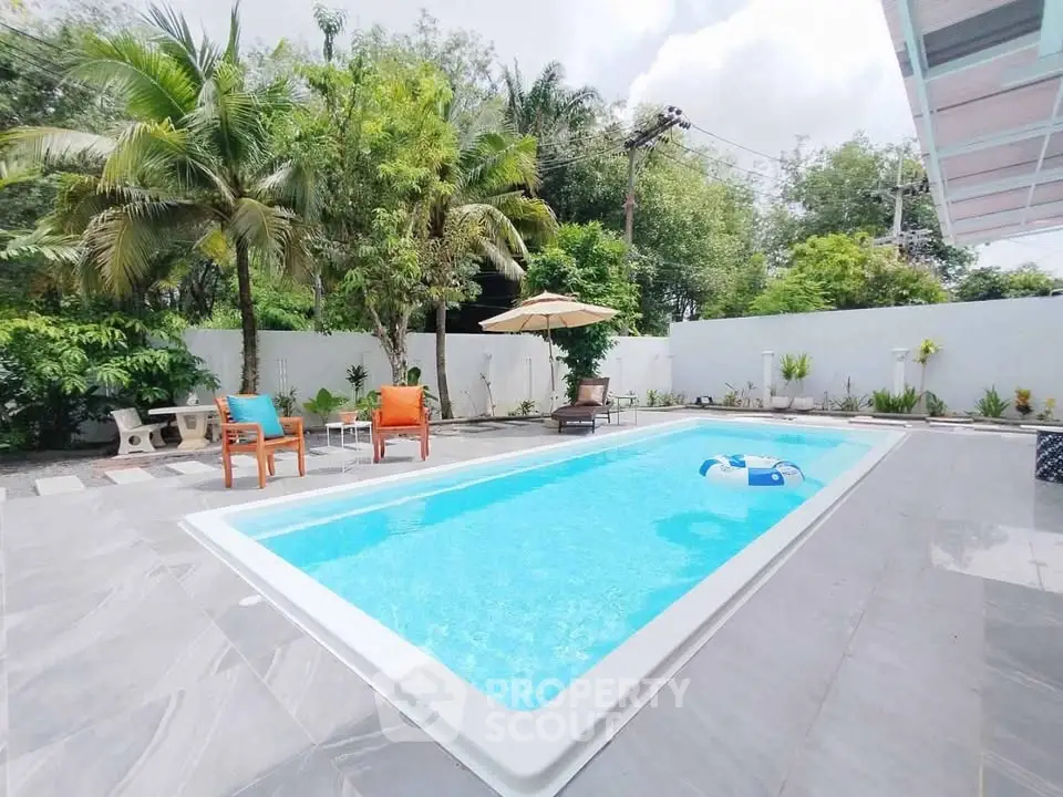 Luxurious backyard with sparkling pool and lush greenery, perfect for relaxation and entertaining.