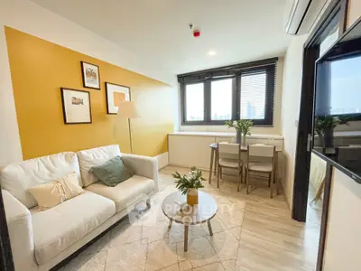 Chic modern living room with vibrant yellow accent wall and cozy seating area.