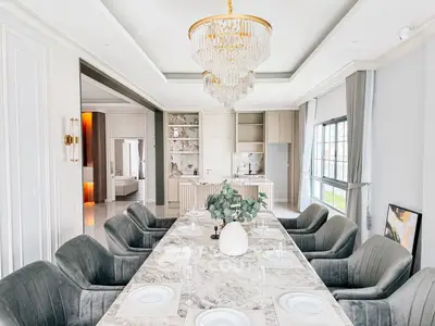 Luxurious dining room with elegant chandelier and marble table in modern open-plan layout.