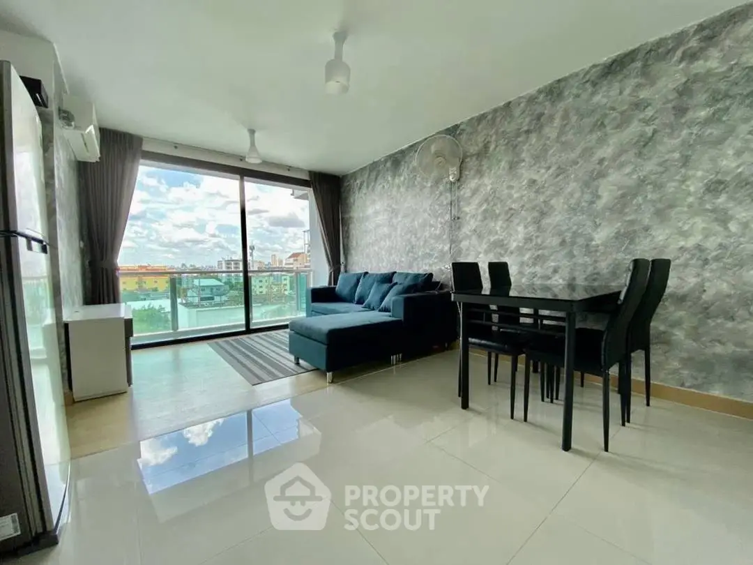 Modern living room with large windows and stylish furniture in a high-rise apartment.