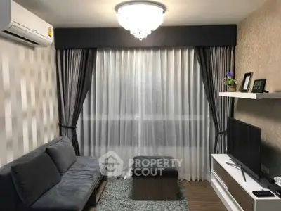 Modern living room with elegant curtains, plush sofa, and sleek TV setup.