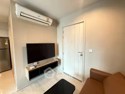 Modern living room with sleek TV setup and air conditioning in a cozy apartment.
