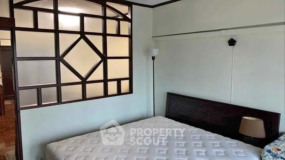 Spacious bedroom with unique wooden partition and cozy lighting